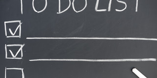 To Do List auf Tafel Liste mit Überschrift "To Do List", auf einer Tafel mit Kreide geschrieben.